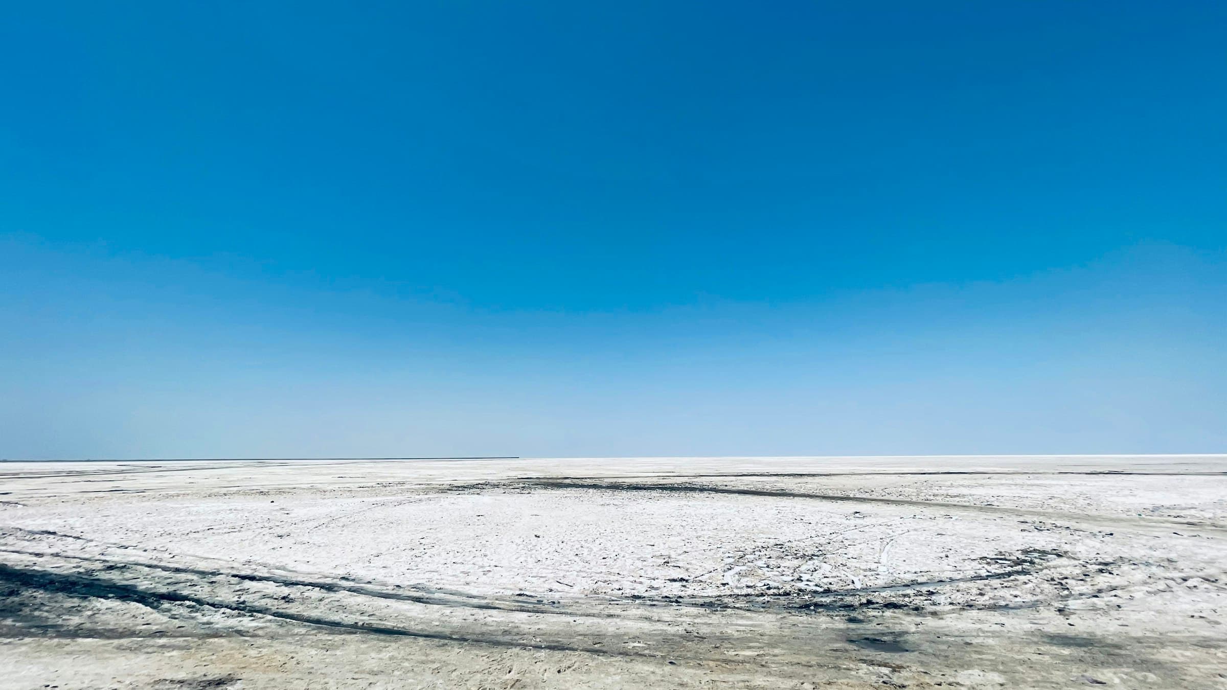 White salt flats of the Rann of Kutch stretching to the horizon under a pale sky