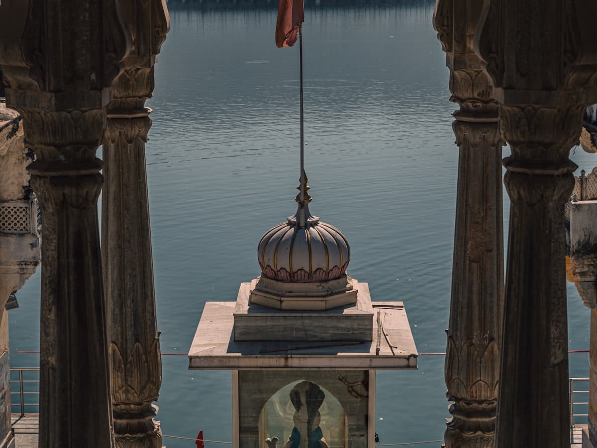 An ornate archway framing a statue by the ghats of Pushkar Lake, Rajasthan