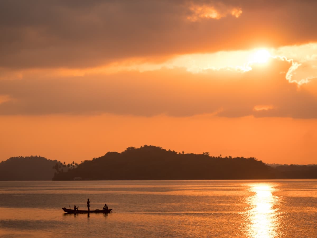 Small boat crossing open water at golden hour near Port Blair, Andaman Islands
