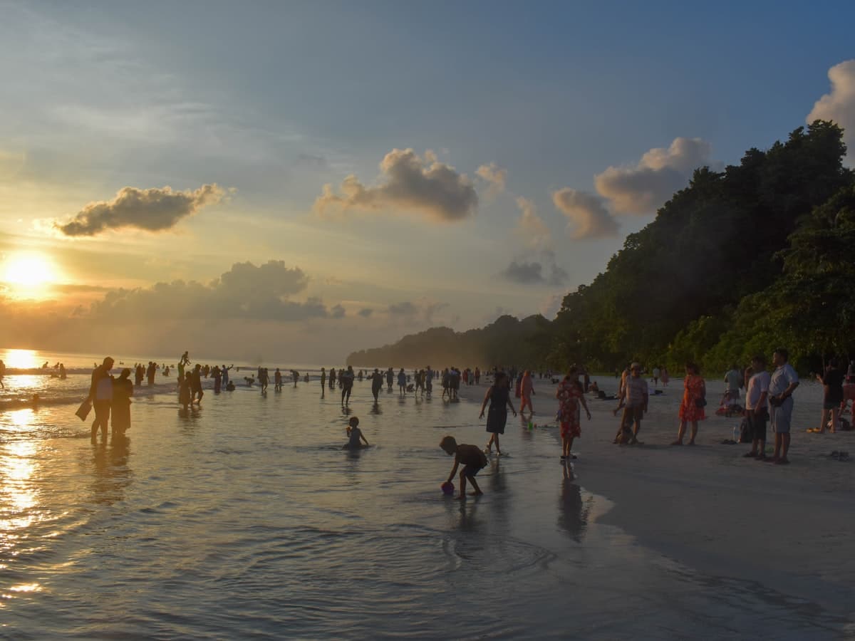 Visitors on the pale sand shoreline of Radhanagar Beach, Havelock Island, Andaman Islands