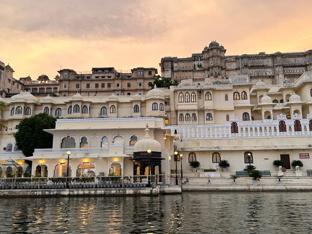 City Palace on Lake Pichola's banks at golden hour, reflecting in calm waters
