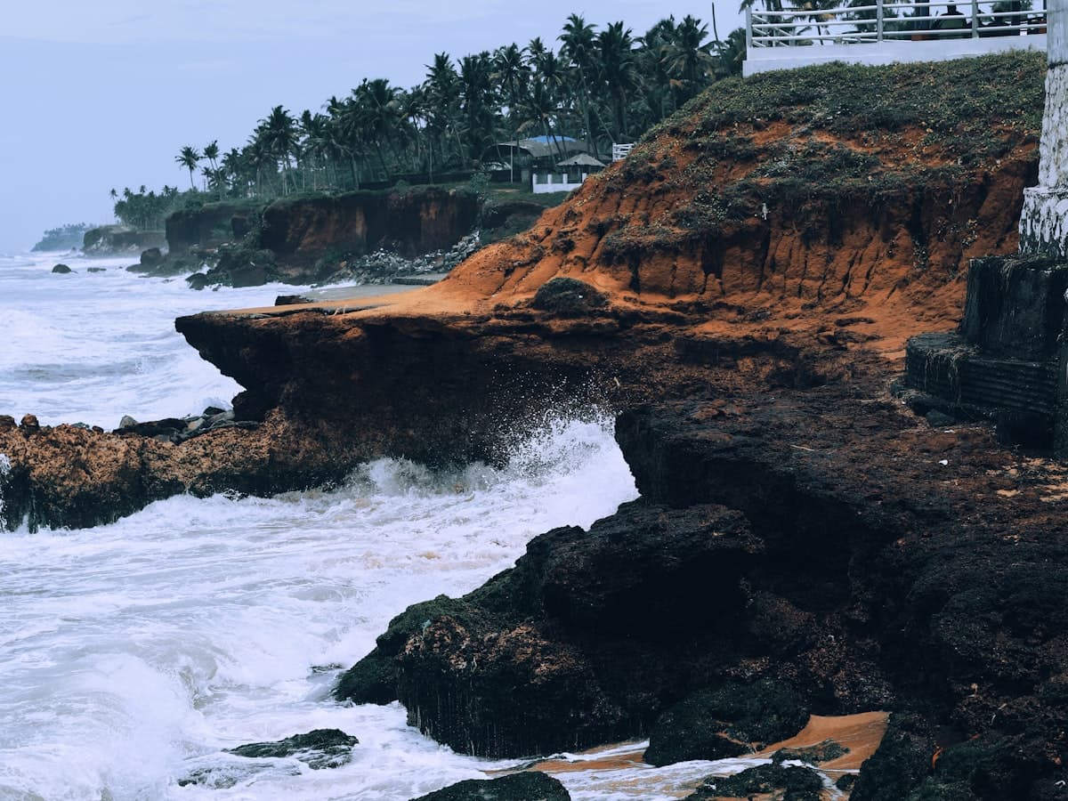 A rocky beach below the laterite cliffs at Varkala with a building on the shore