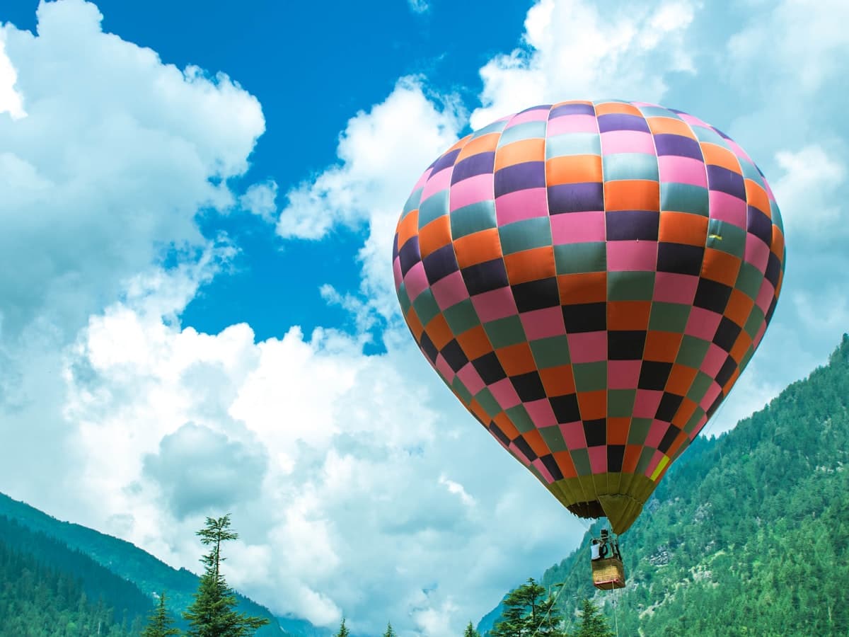 A yellow, red and blue hot air balloon under a blue sky