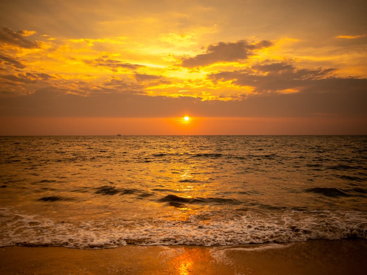 The sun setting over the water at the beach
