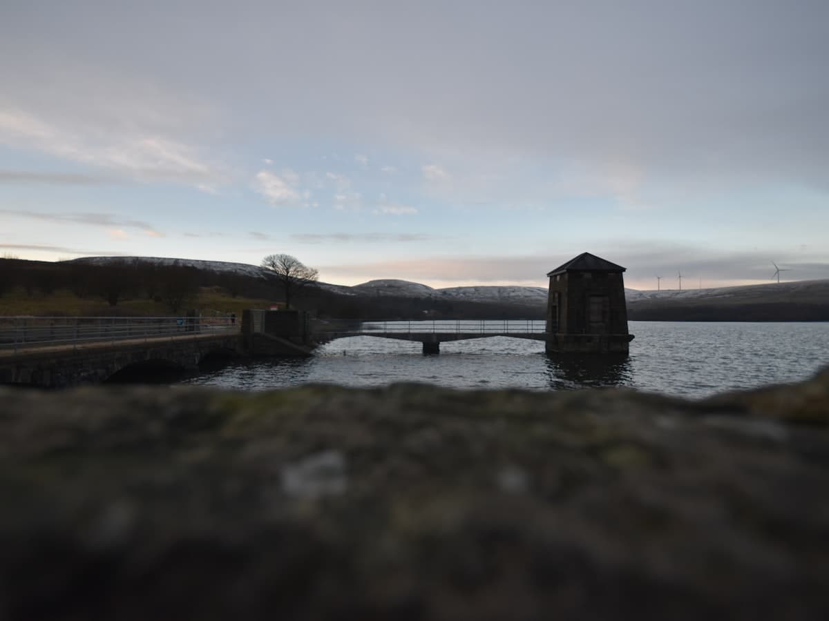 A body of water with a bridge in the background
