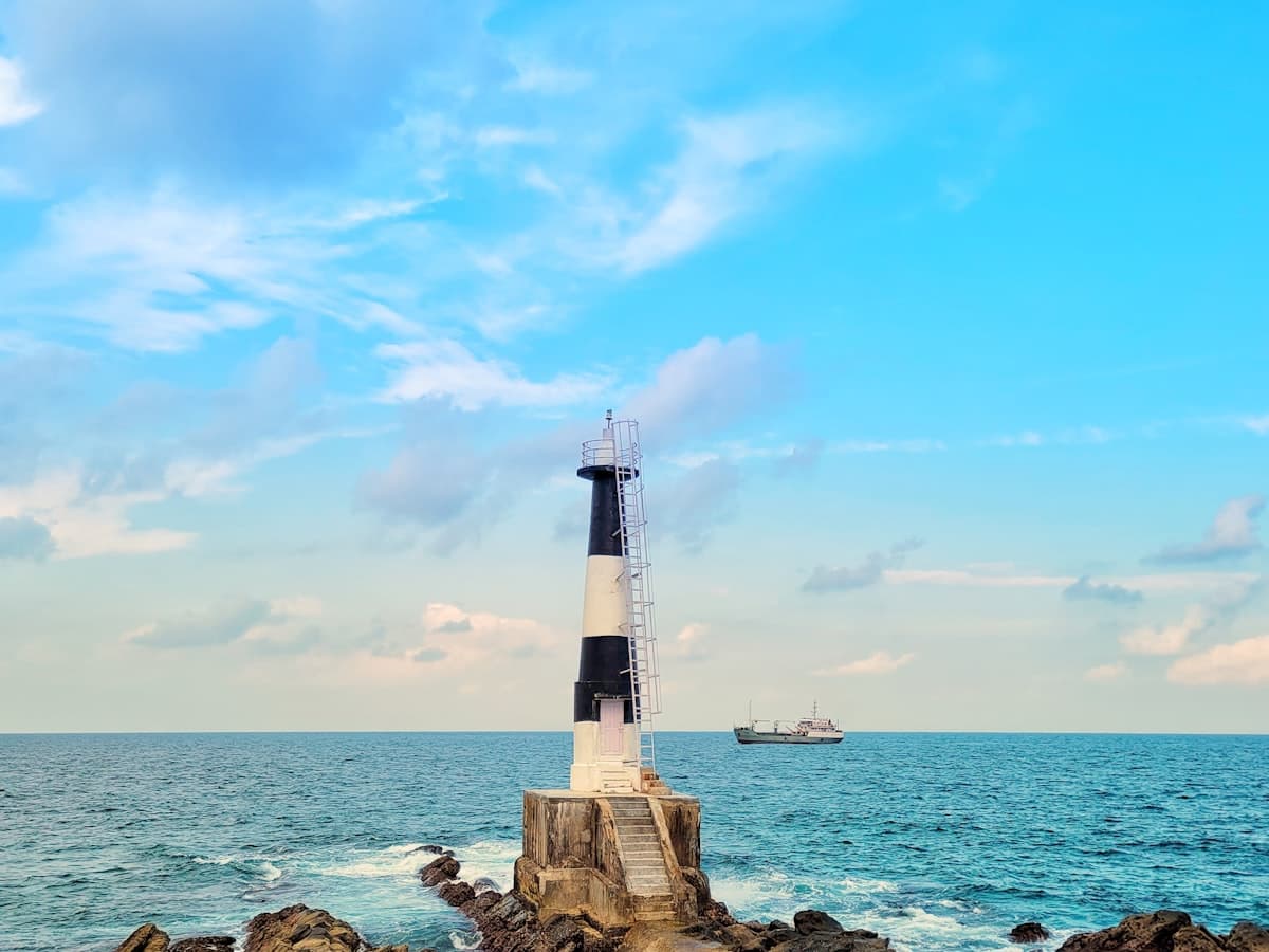 A lighthouse sitting on top of a rock near the ocean