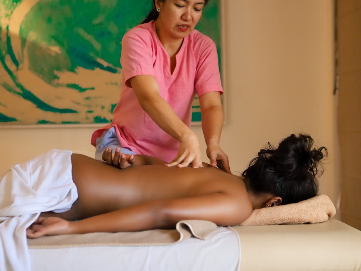 A person receiving a back massage at a spa